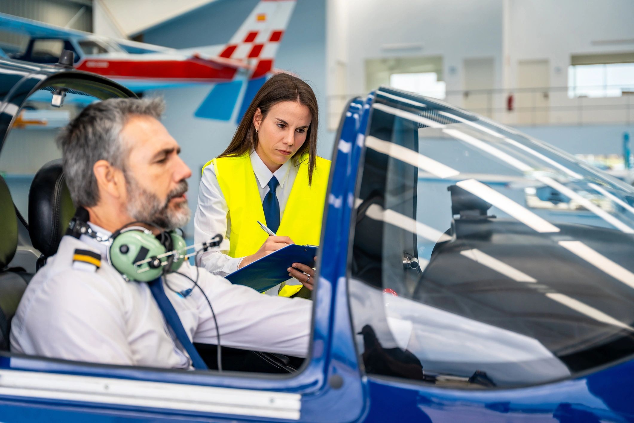Pilot and technician reviewing a checklist in a hangar